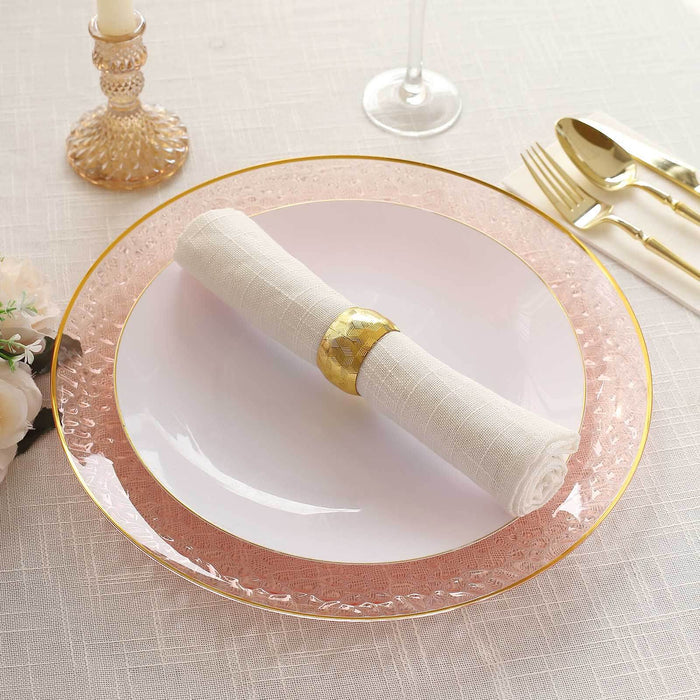 Elegant table setting with a pink plate and rolled napkin.