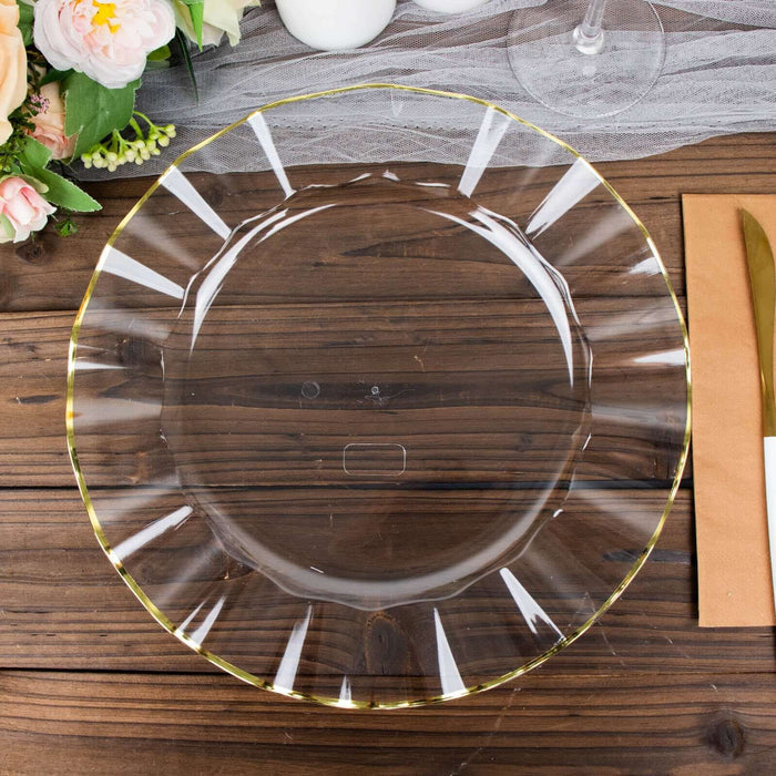 Clear glass plate with gold trim on a wooden table.