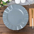 Gray decorative plate with a scalloped edge on a wooden table.