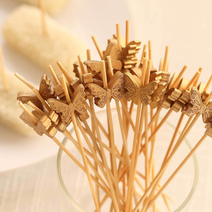 Wooden butterfly appetizer picks in a clear glass vase.