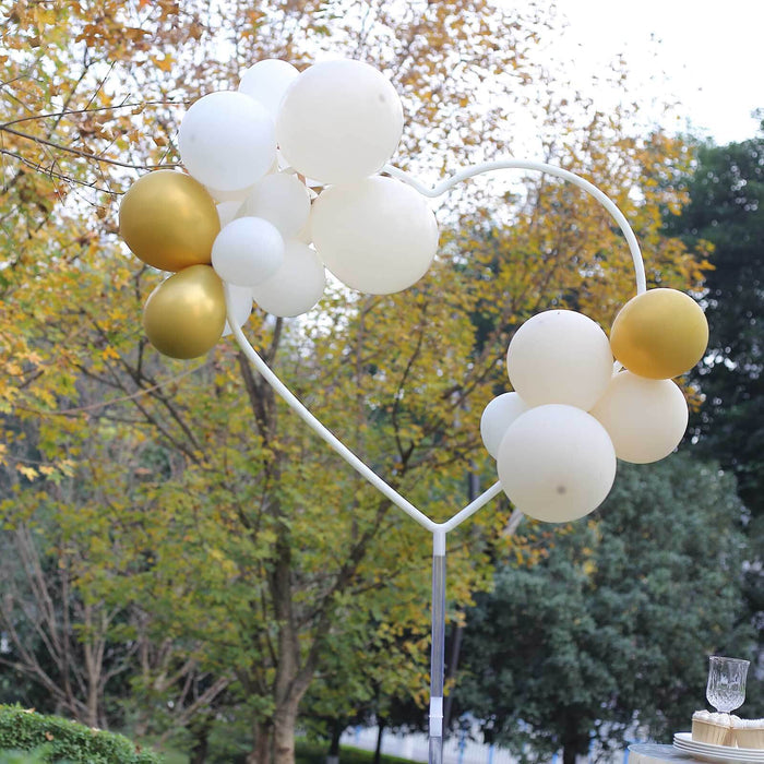 Heart-shaped balloon arch in gold and white for events and celebrations.